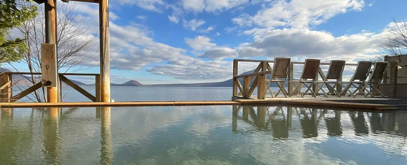 Pemandian umum pria dengan pemandangan luar ruangan.