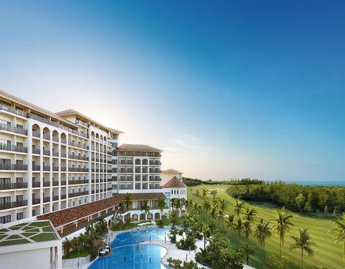 朝日差し込むゴルフ場と緑に寄り添うホテル