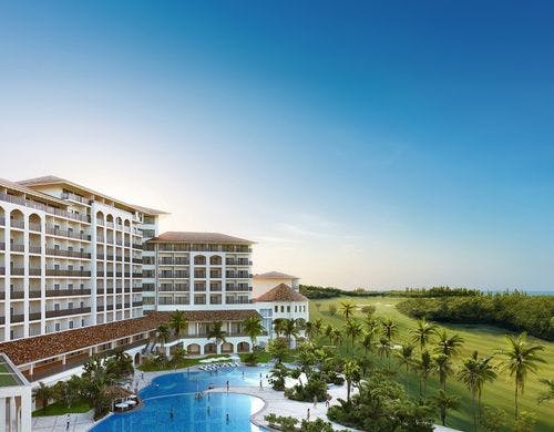 朝日差し込むゴルフ場と緑に寄り添うホテル