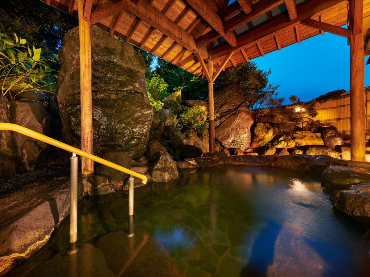 บ่อน้ำพุร้อนกลางแจ้งยามพระอาทิตย์ตกดิน.