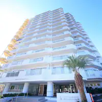 คอนโดมิเนียมหอคอยสีขาวที่ตั้งตระหง่านบนที่สูง.