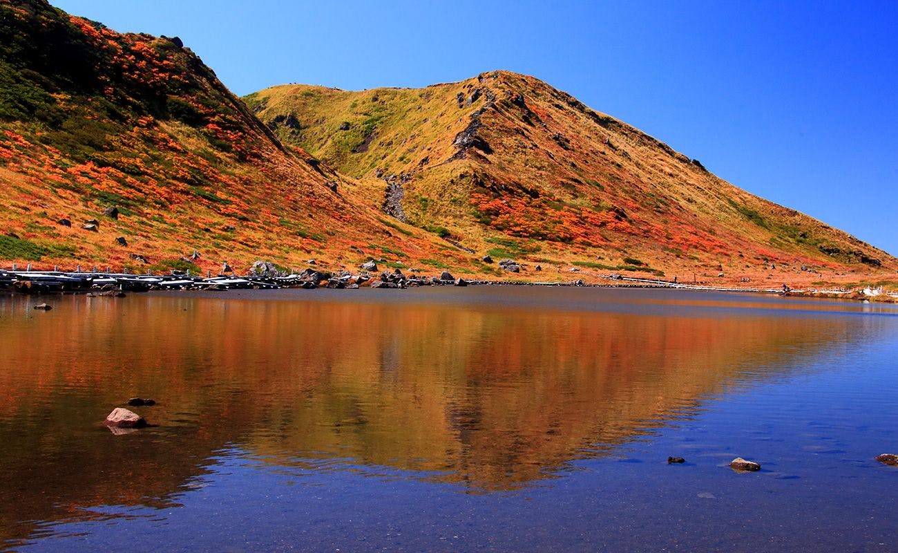 ภูเขาอาคิตะโคมากาตาเกะที่ล้อมรอบด้วยใบไม้เปลี่ยนสี.