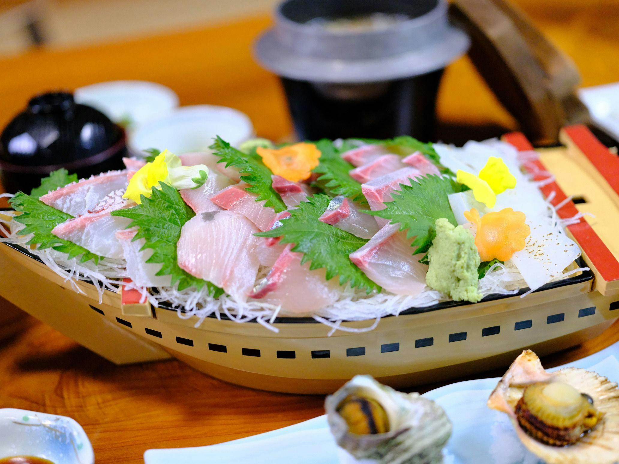 Hidangan sashimi pelbagai jenis dalam susunan seperti perahu