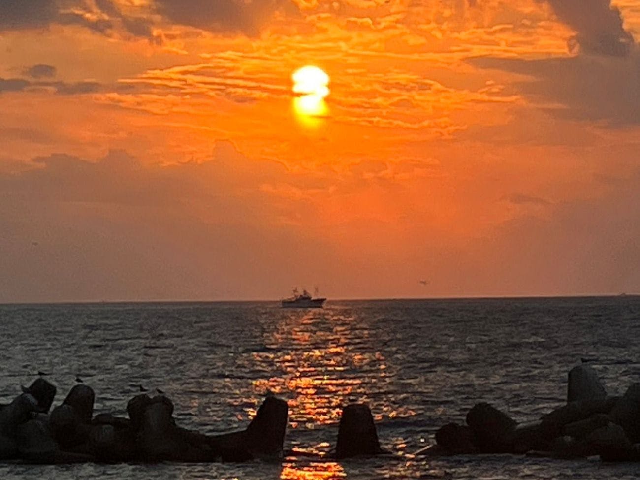 พระอาทิตย์ตกดินในทะเลญี่ปุ่นและเรือ