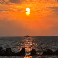 พระอาทิตย์ตกดินในทะเลญี่ปุ่นและเรือ