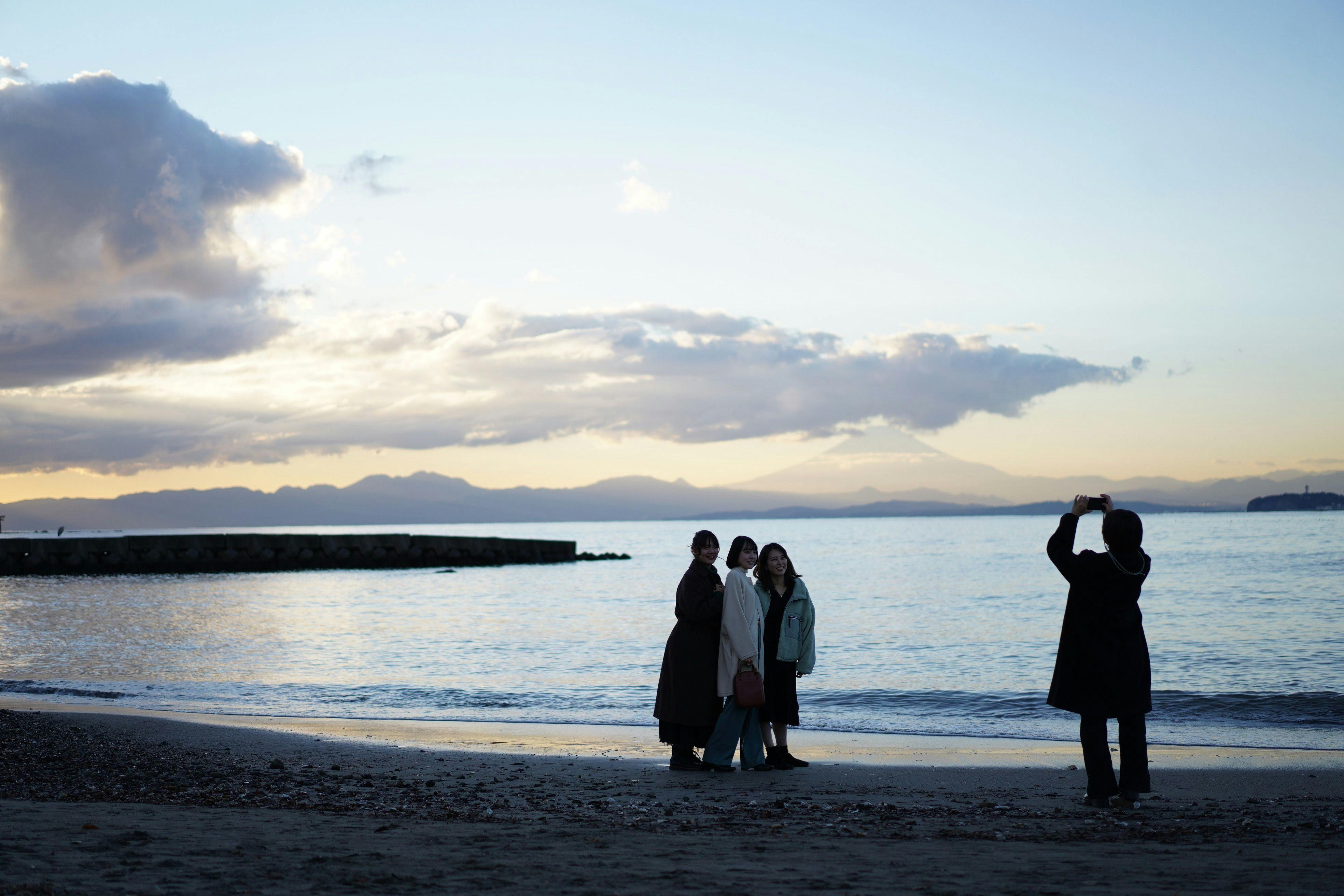 ถ่ายภาพที่ระลึกโดยมีพระอาทิตย์ตกดินที่ชายหาดโมริโตะเป็นฉากหลัง