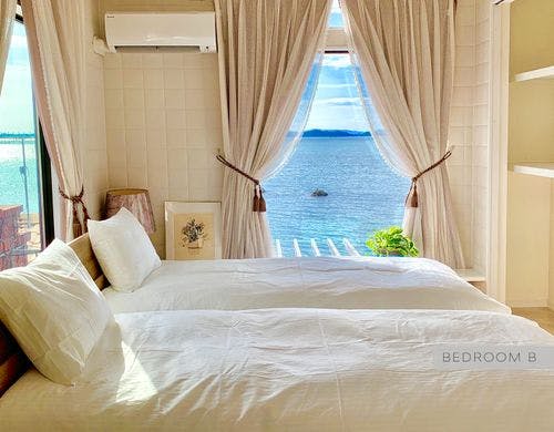 白のタイル張りの明るいベッドルームです。