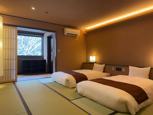 Kamar dengan dua ruangan yang terhubung dan dilengkapi dengan pemandian semi terbuka.