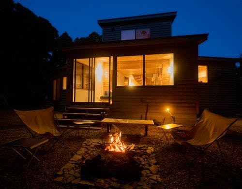 川から眺めるファイヤーピットとリビング