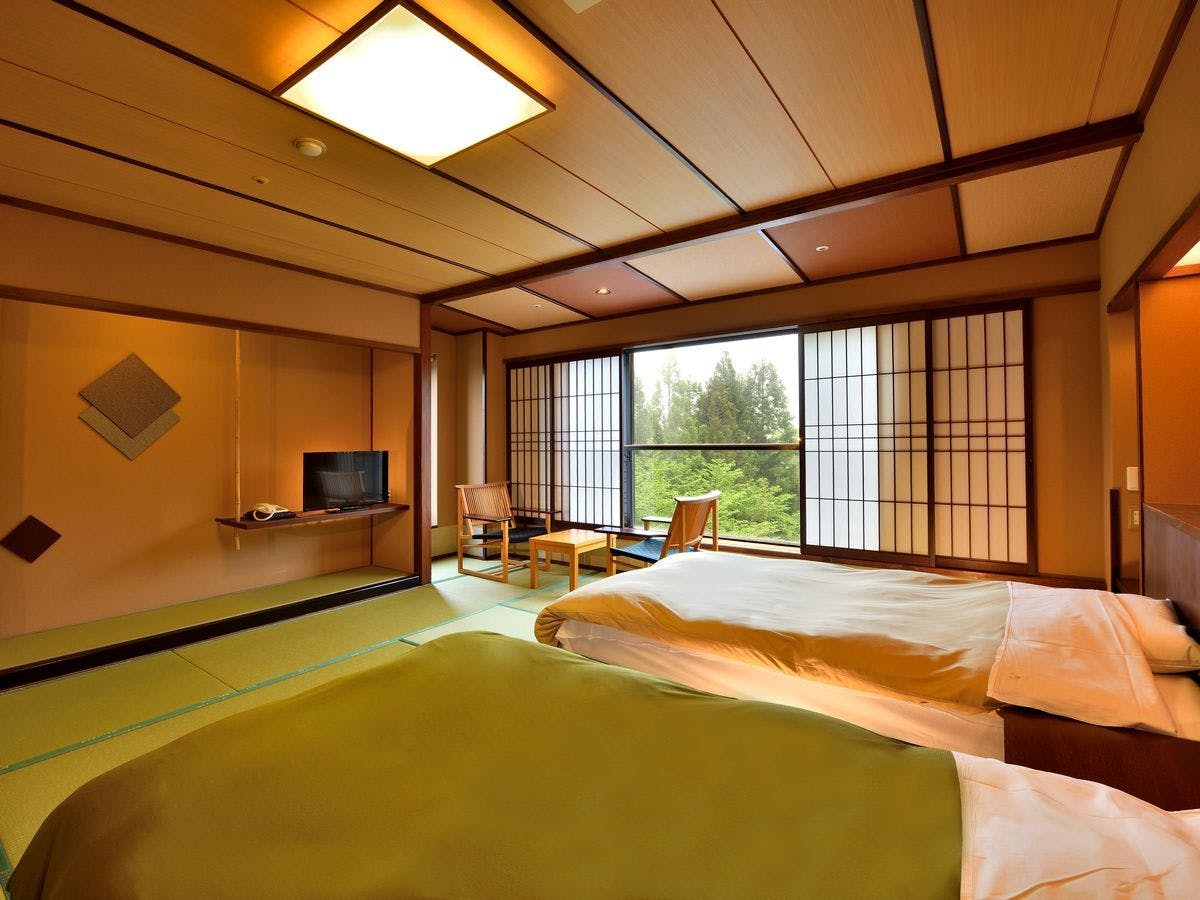 Kamar bergaya Jepang modern dengan dua tempat tidur single.