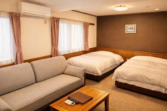 Kamar dengan 2 tempat tidur semi-double, dilengkapi wastafel dan toilet.