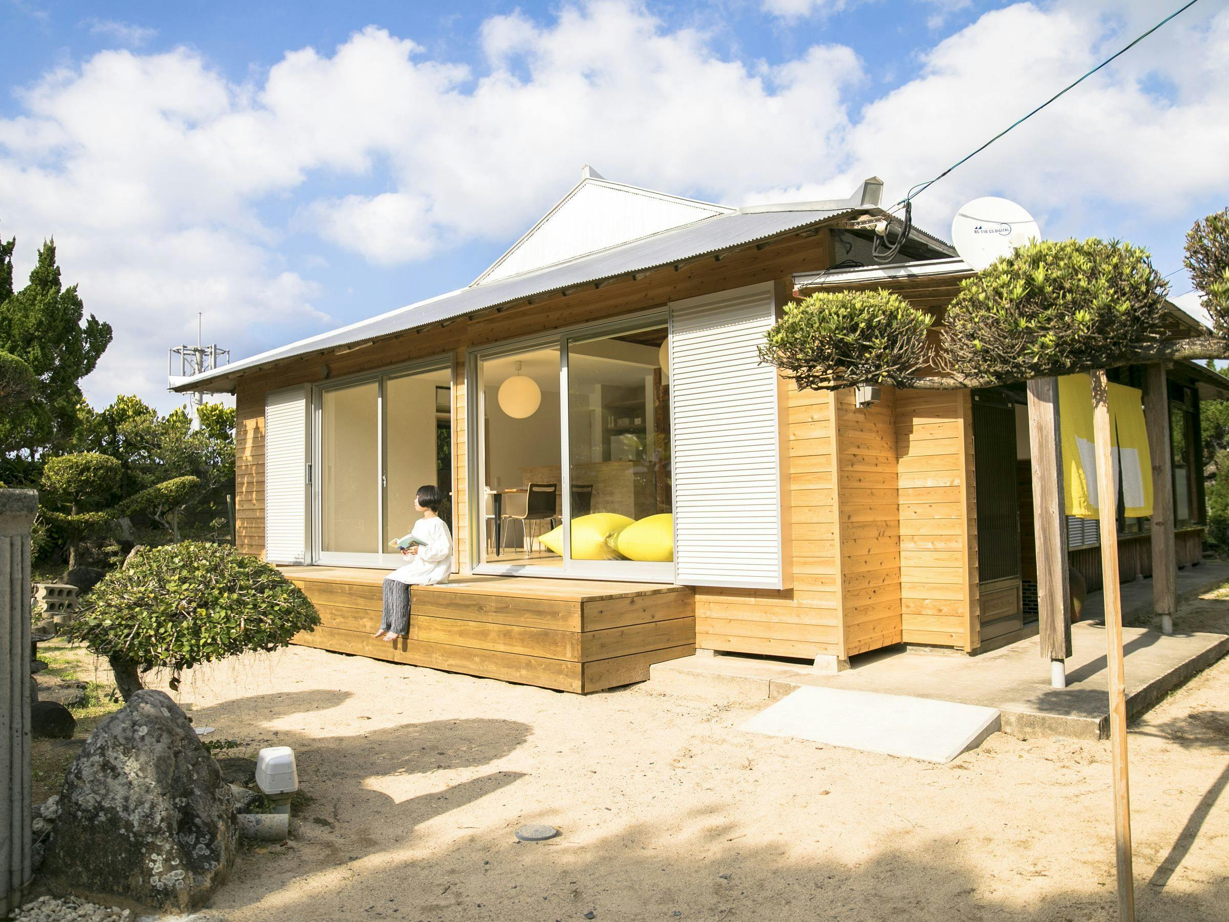 Eksterior Akomodasi dengan dinding batu karang dan tanaman taman.