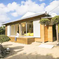 Eksterior Akomodasi dengan dinding batu karang dan tanaman taman.