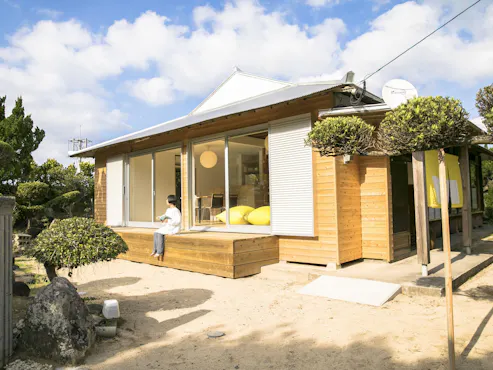 Eksterior Akomodasi dengan dinding batu karang dan tanaman taman.