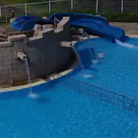 Kolam renang dilengkapi dengan seluncuran kecil.