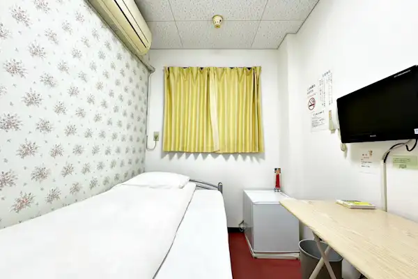 Kamar Single dengan Wallpaper Bermotif Bunga