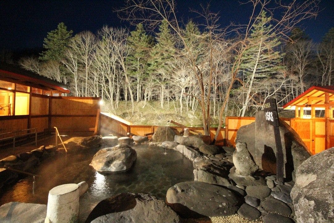 Pemandian air panas terbuka besar yang diterangi lampu