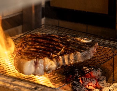 薪で焼き上げる豪快な肉