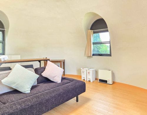 丸みのある壁と白を基調とした寝室空間