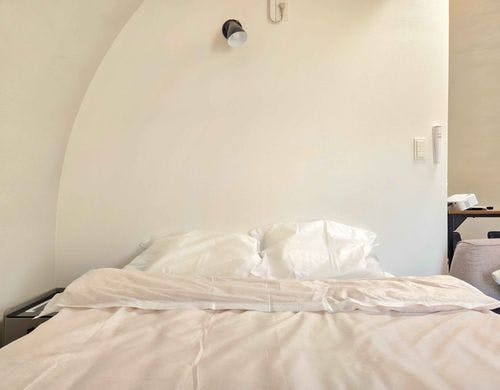 丸みのある壁と白を基調とした寝室空間