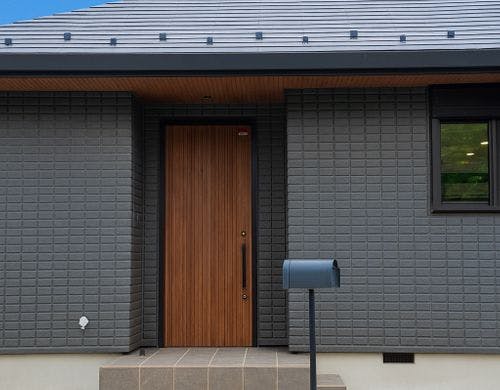 黒基調で木目のアクセントが美しい外観
