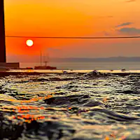 Pemandangan matahari terbenam dari pemandian air panas terbuka di atap (diambil pada bulan Mei)