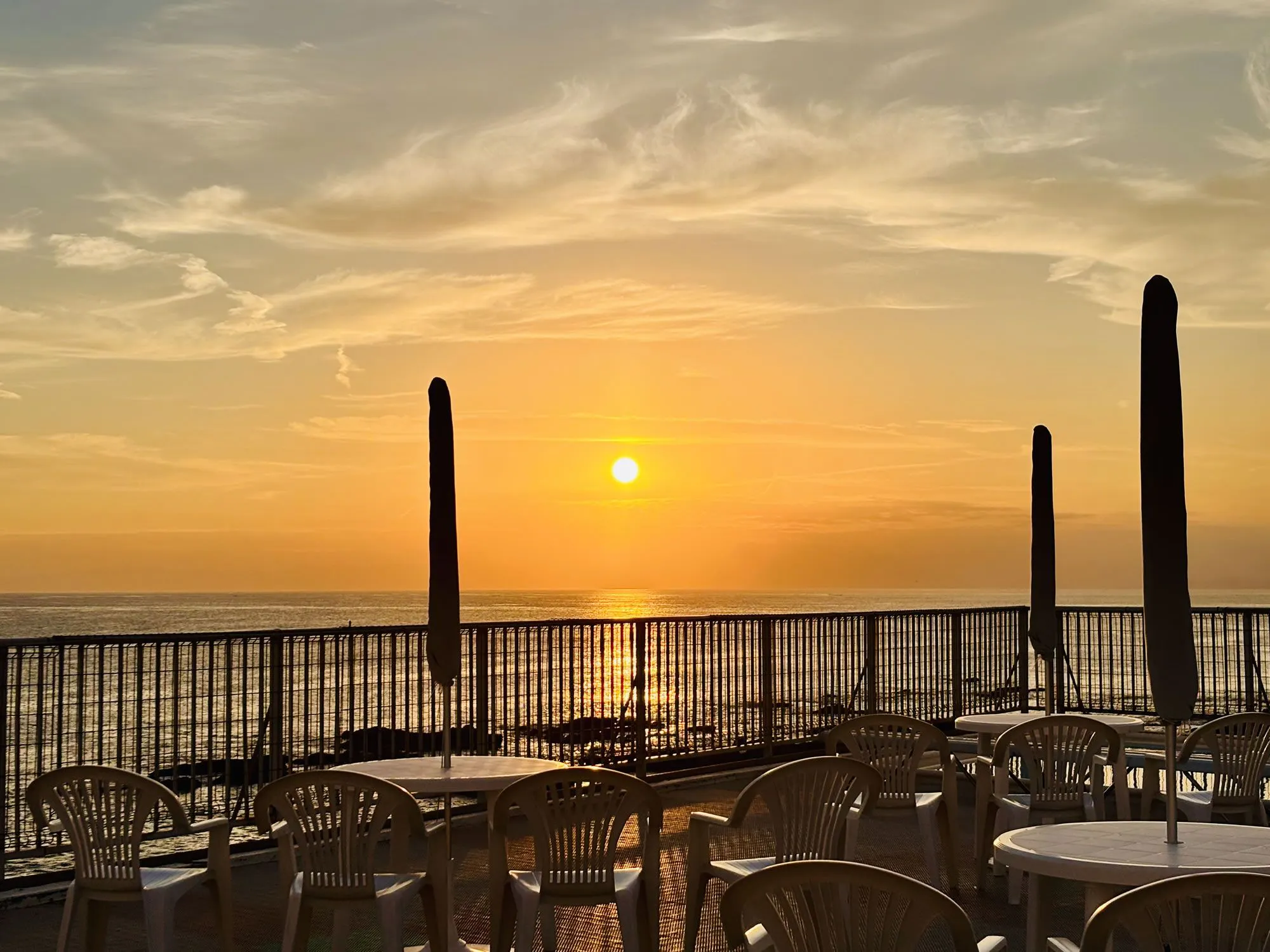 พระอาทิตย์ตกดินจากริมสระว่ายน้ำเป็นภาพที่งดงาม