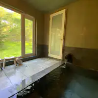 จากอ่างอาบน้ำในร่มที่มีน้ำพุร้อนธรรมชาติ คุณสามารถมองเห็นป่าได้