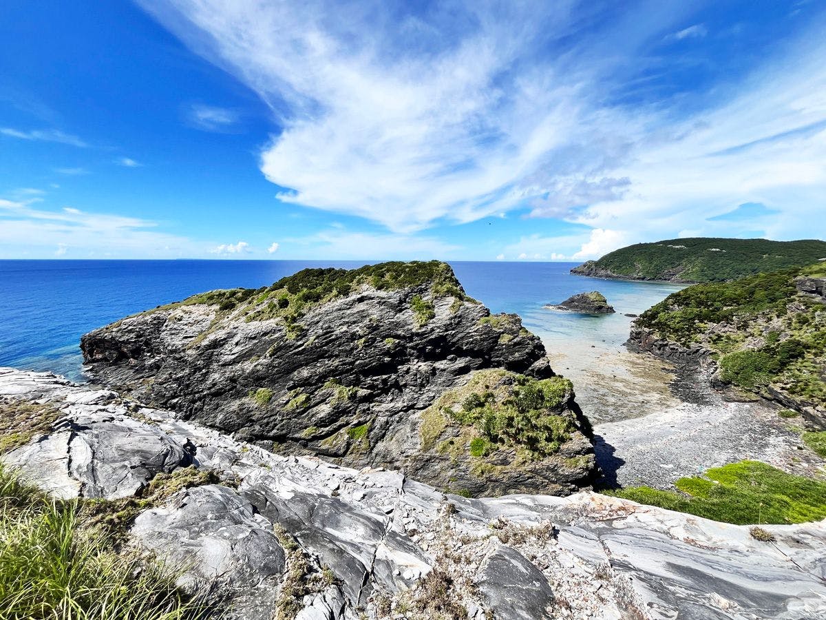 หน้าผาหินชั้นที่สลับซับซ้อนและทะเลสีฟ้าใส