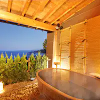 ห้องอาบน้ำกลางแจ้งในห้องพักพร้อมวิวทะเลญี่ปุ่นและแสงไฟจากเรือประมง