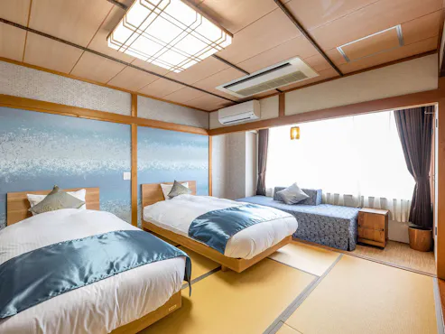 Kamar bergaya Jepang dengan 2 tempat tidur dan 1 sofa bed.