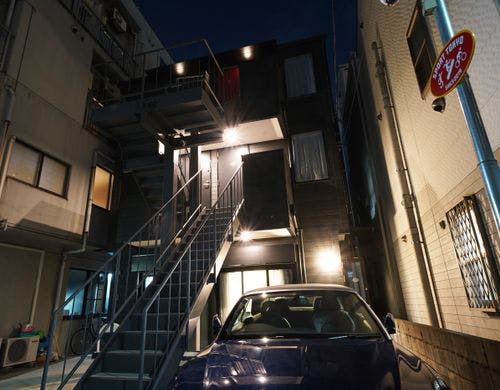 黒い外壁が光に照らされるシックな佇まい。