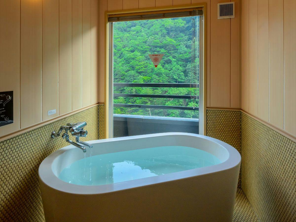窓いっぱいの緑を望む源泉かけ流しバス
