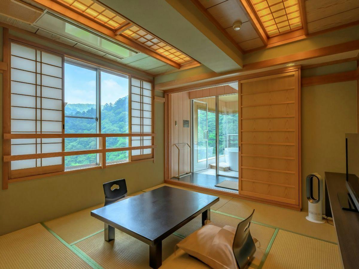 窓いっぱいの緑に寛ぐ、温もりの和の客室