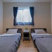 ห้องพักสองห้องที่มีเตียงเดี่ยวสองเตียงในแต่ละห้อง