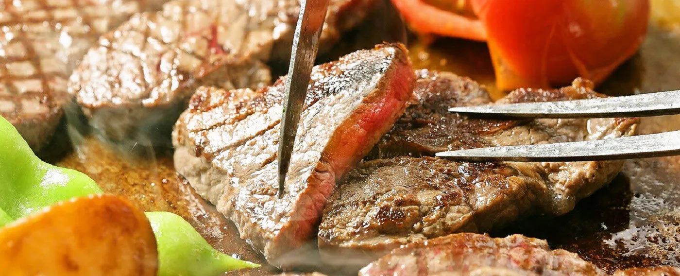 Steak daging sapi yang juicy dipanggang di panggangan terbuka di tempat prasmanan.