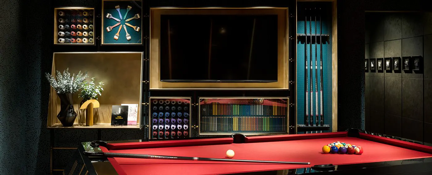 2階ラウンジ|ビリヤード台と、刺繍糸や筆などを使ったアート