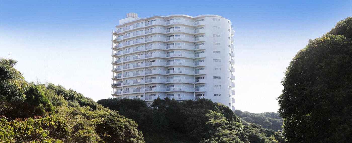 คอนโดมิเนียมสูง 14 ชั้นที่ตั้งอยู่บนเนินเขาเล็ก ๆ