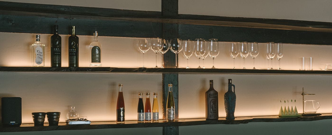 【每日僅接待一組貴賓・特別棟】廚房吧檯後方陳列著精選的在地清酒與酒杯