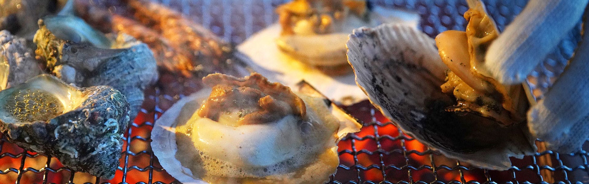 海が目の前のテラスで館主自身が目の前で炭火焼に。