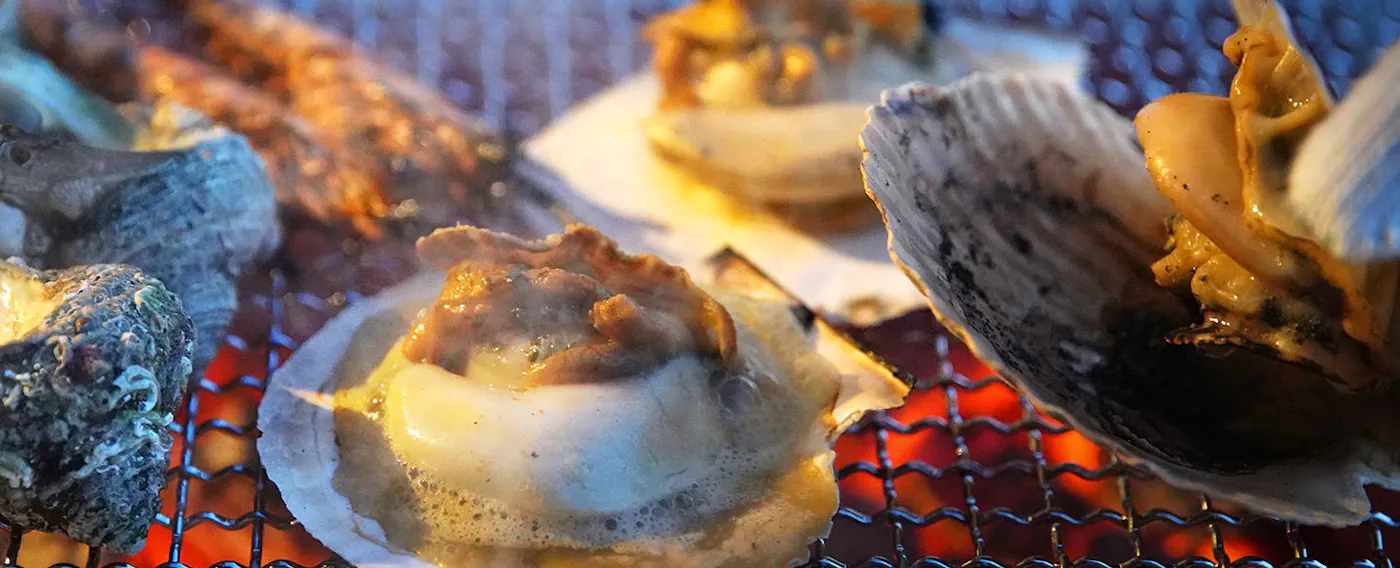 海が目の前のテラスで館主自身が目の前で炭火焼に。