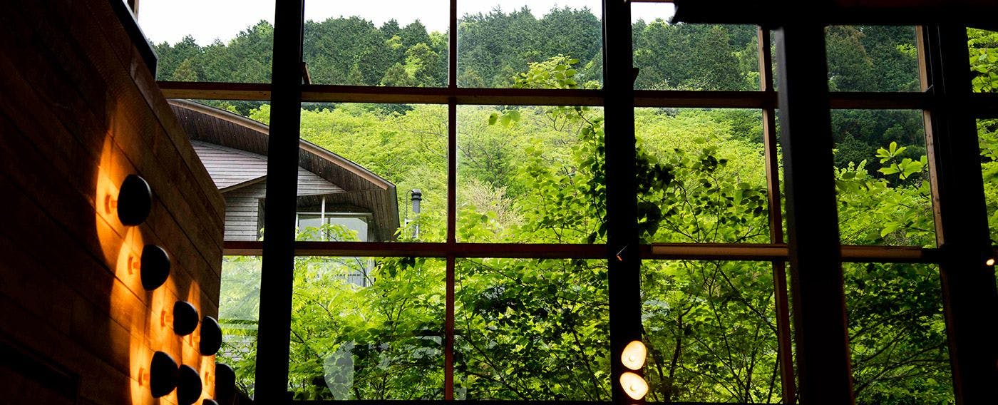 Ruang makan dengan langit-langit tinggi dan suasana terbuka yang dipenuhi kaca.