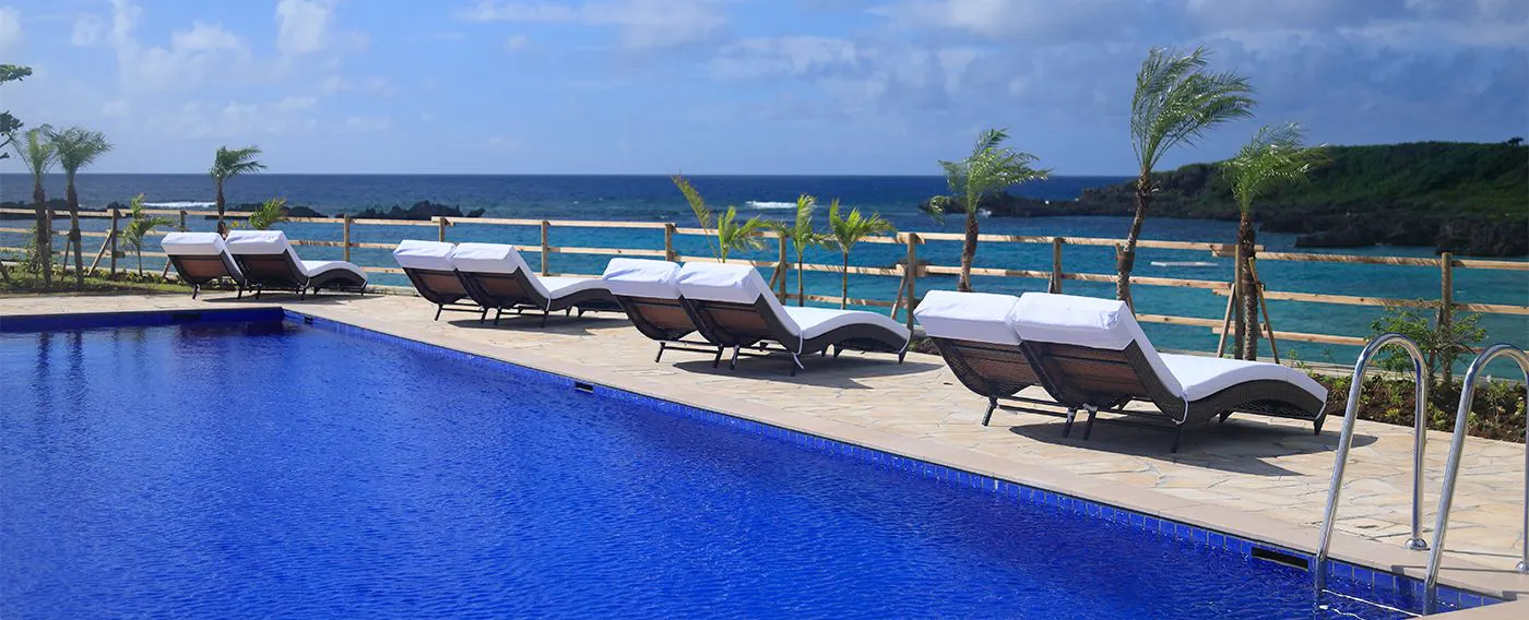 <สระว่ายน้ำริมทะเล> สระว่ายน้ำสำหรับผู้ใหญ่ ตั้งอยู่ใกล้ชายหาดชิกิระ บนจุดชมวิวที่สูงขึ้นเล็กน้อย