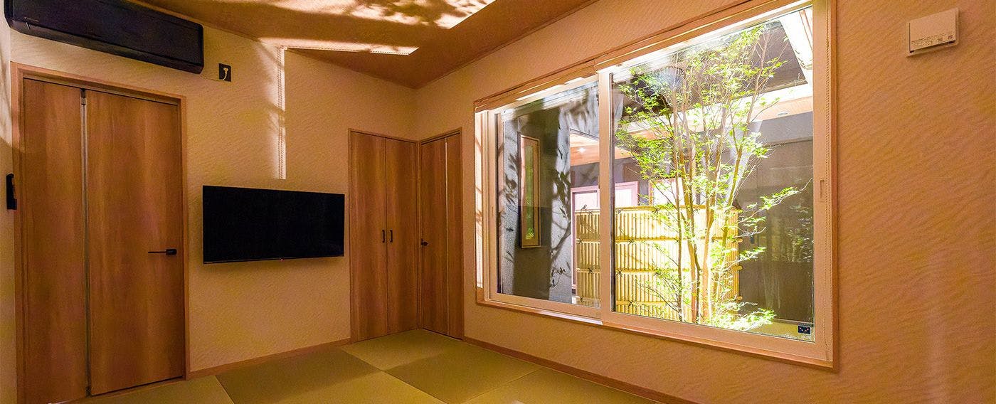 【鳳凰館・和室】中庭を眺められる大きな窓から差し込む木漏れ日